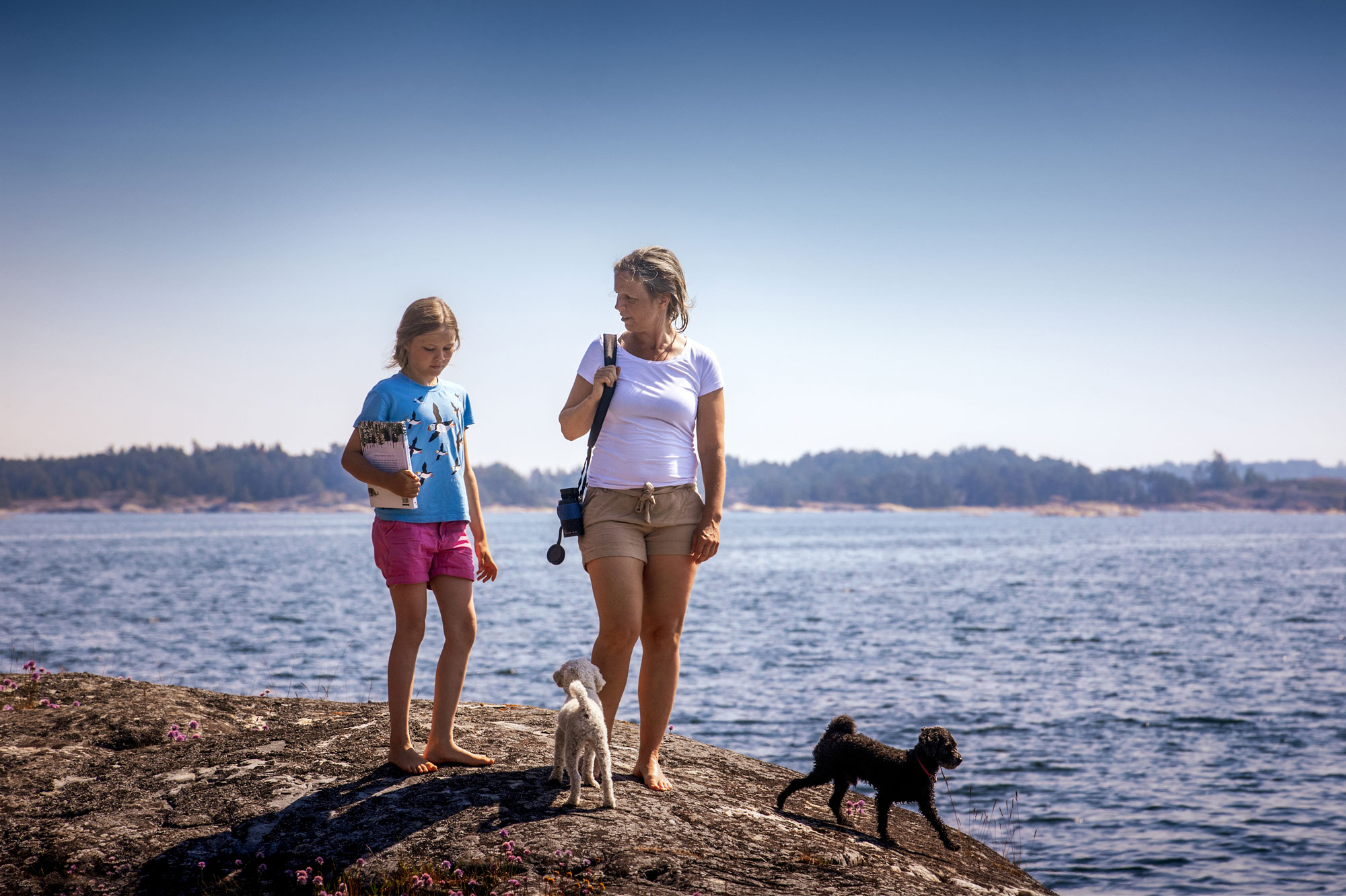 Foto på Anna-Lena Laurén med sitt barn och sina hundar.